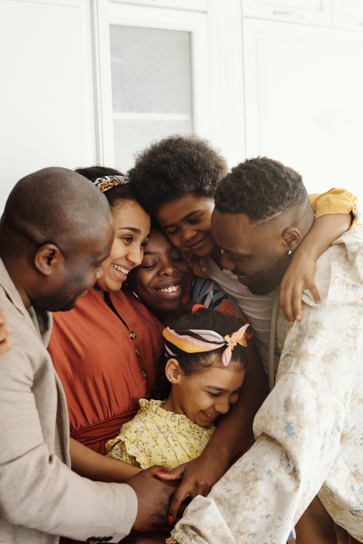 A multigenerational family sharing a warm embrace at home